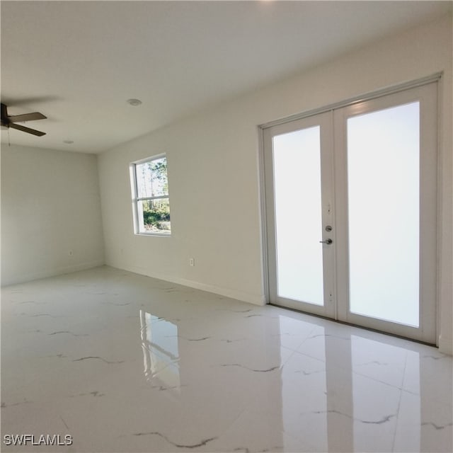 empty room featuring ceiling fan and french doors