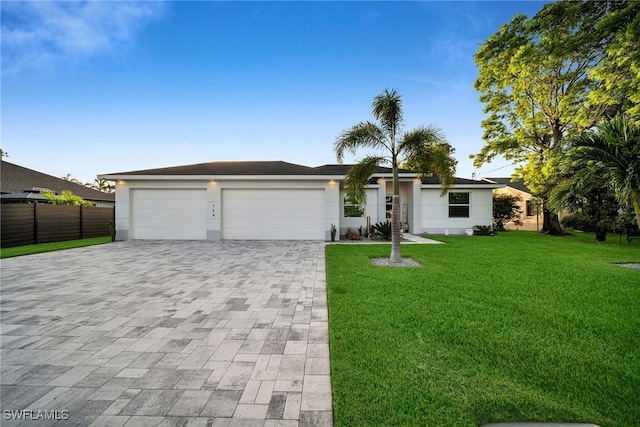 single story home featuring a front lawn and a garage