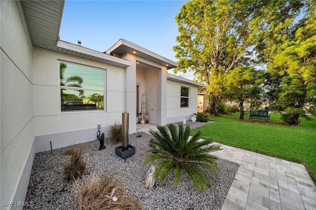 entrance to property featuring a lawn