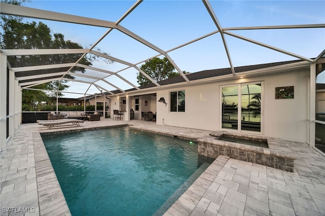 view of pool with outdoor lounge area, a patio area, and glass enclosure