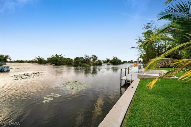 dock area featuring a lawn and a water view