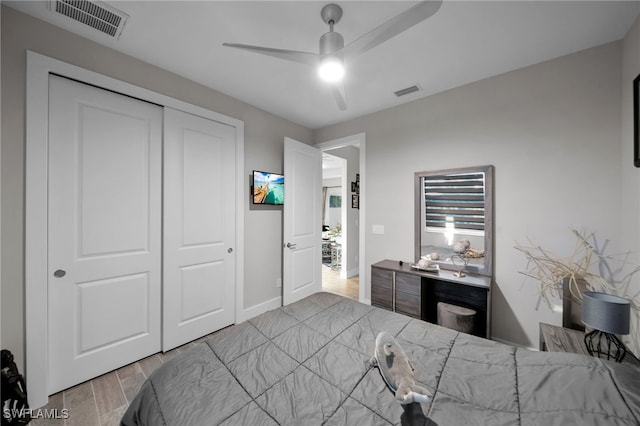 bedroom with a closet, light hardwood / wood-style flooring, and ceiling fan