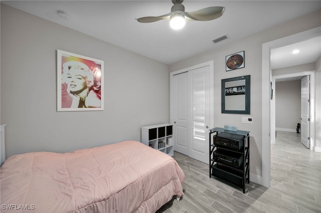 bedroom with ceiling fan, light hardwood / wood-style floors, and a closet