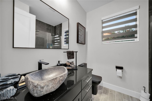 bathroom featuring a shower with shower door, toilet, wood-type flooring, and vanity