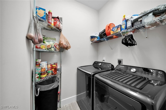 laundry room with hardwood / wood-style flooring and washing machine and clothes dryer