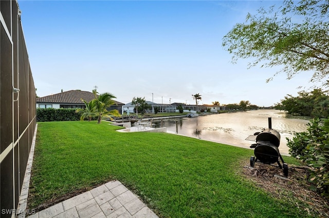 view of yard with a water view and a boat dock