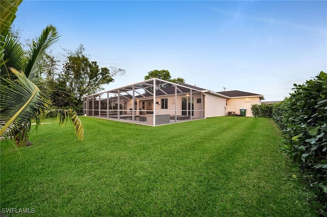 back of property featuring a lanai and a yard