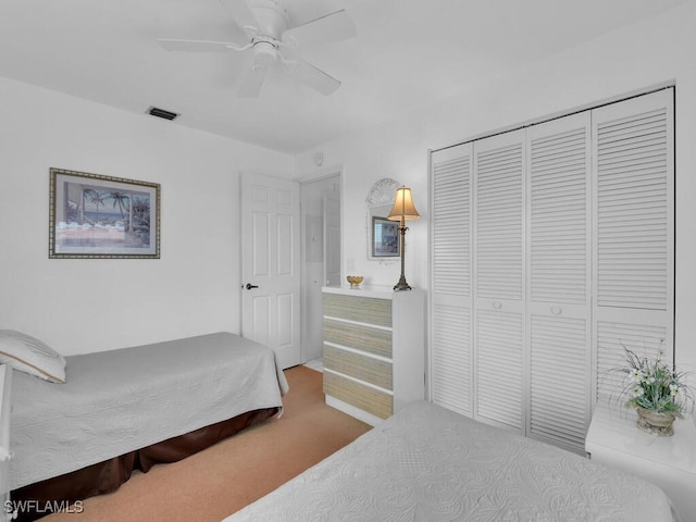 carpeted bedroom featuring ceiling fan and a closet