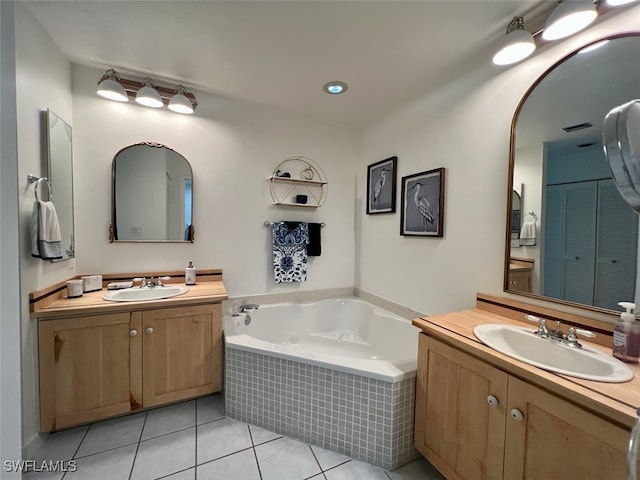 bathroom featuring vanity, tile patterned floors, and tiled tub