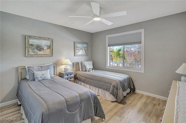 bedroom featuring ceiling fan, light hardwood / wood-style flooring, and a textured ceiling