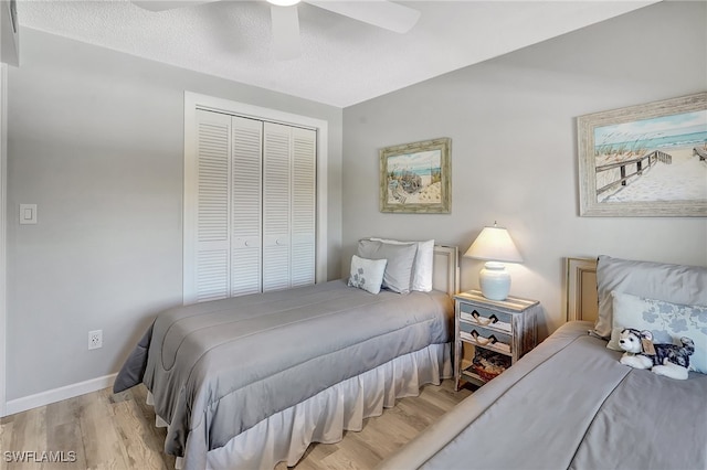 bedroom featuring ceiling fan, a textured ceiling, light wood-type flooring, and a closet