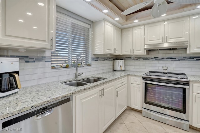 kitchen with light tile patterned flooring, sink, appliances with stainless steel finishes, light stone countertops, and white cabinets