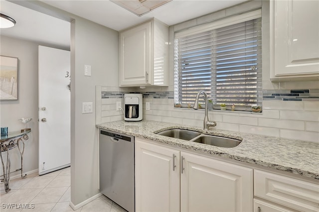 kitchen featuring white cabinetry, sink, light tile patterned floors, and stainless steel dishwasher