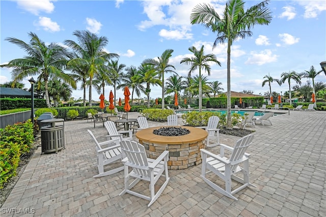 view of patio with a community pool and an outdoor fire pit