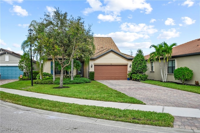 view of front of home with a garage and a front lawn