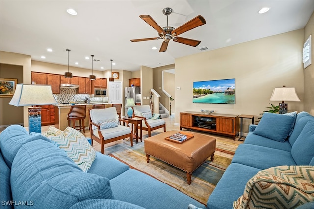 living room with light hardwood / wood-style flooring and ceiling fan