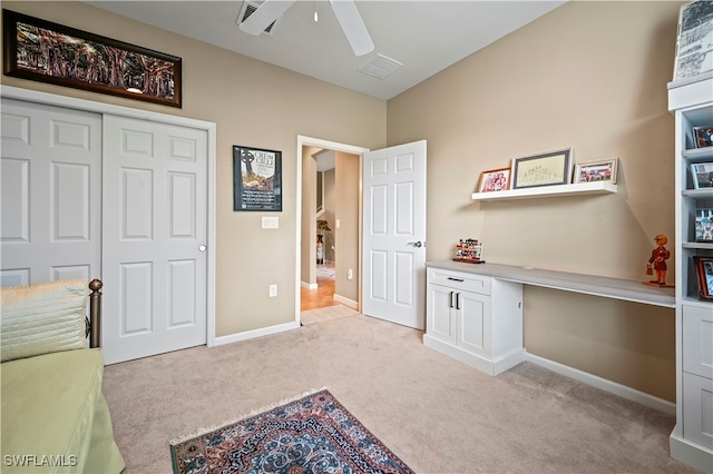 interior space with ceiling fan and built in desk