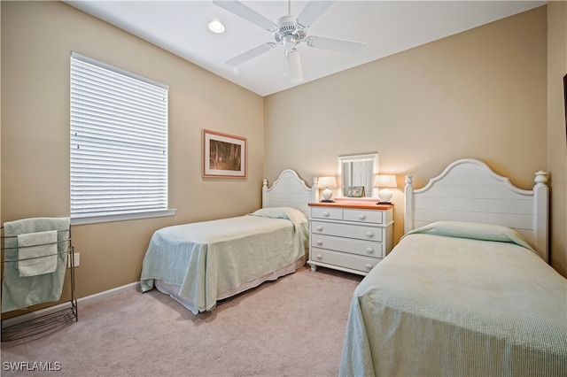 carpeted bedroom featuring multiple windows and ceiling fan