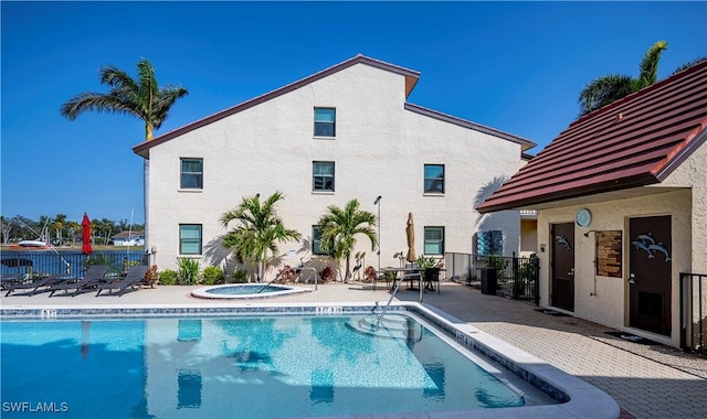 view of swimming pool with a hot tub and a patio