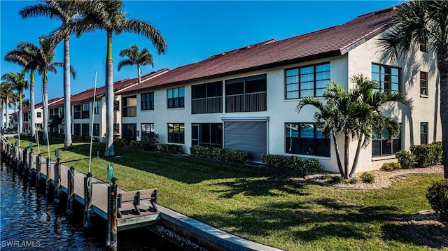 back of property featuring a yard and a water view