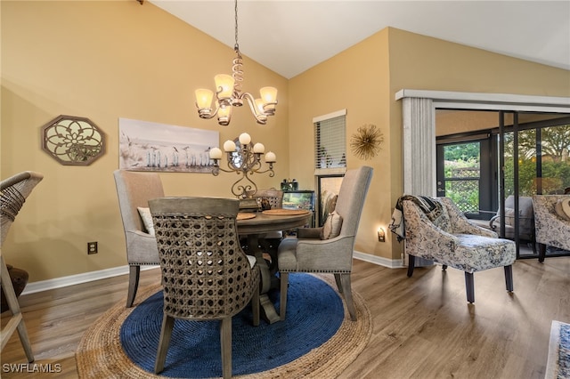 dining area with wood-type flooring, lofted ceiling, and a notable chandelier