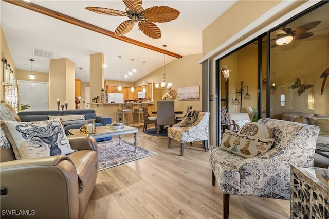 living room with ceiling fan with notable chandelier, light wood-type flooring, and lofted ceiling