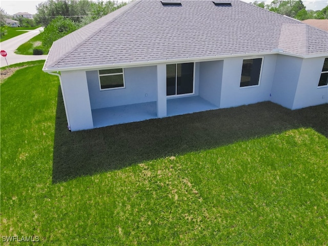 rear view of house with a yard and a patio