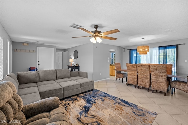 living room with light tile patterned floors, a textured ceiling, and ceiling fan