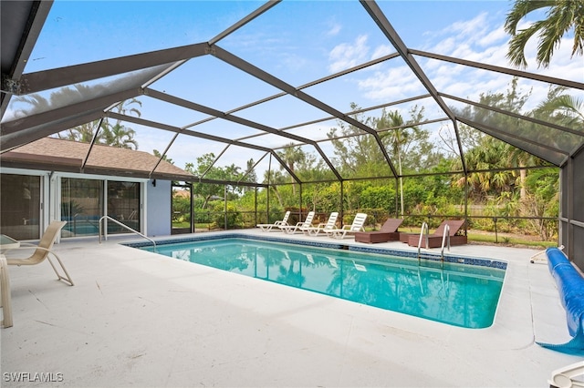 view of swimming pool featuring glass enclosure and a patio