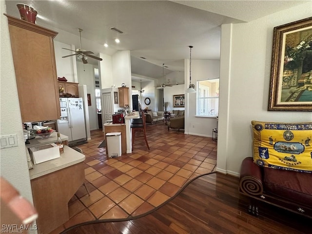 kitchen with lofted ceiling, dark wood-type flooring, ceiling fan, white fridge with ice dispenser, and decorative light fixtures