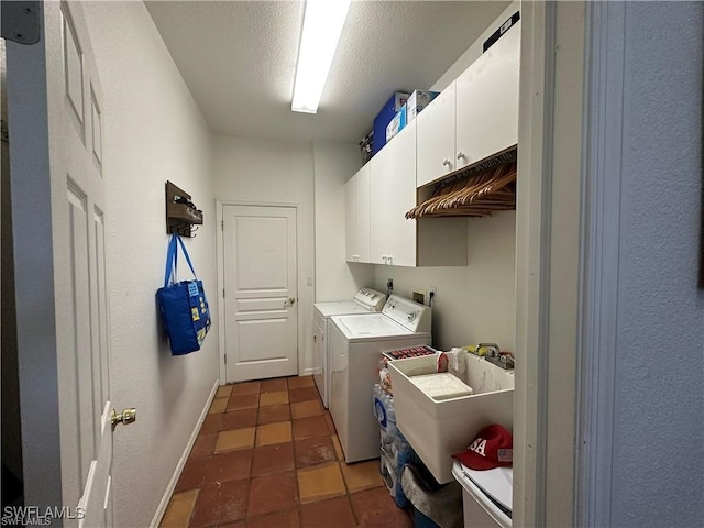 laundry area featuring cabinets, separate washer and dryer, dark tile patterned flooring, and sink