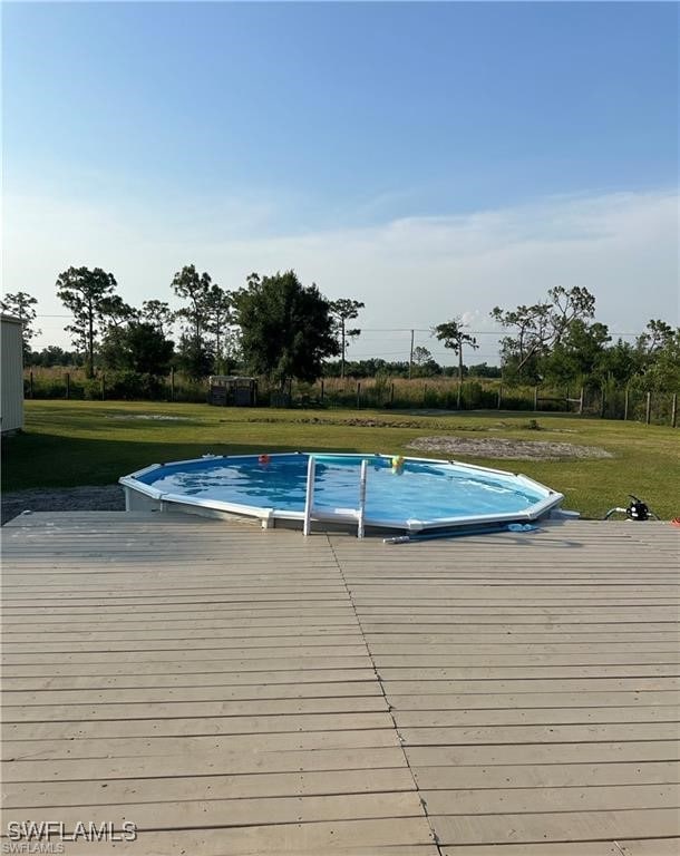 view of swimming pool with a lawn and a wooden deck