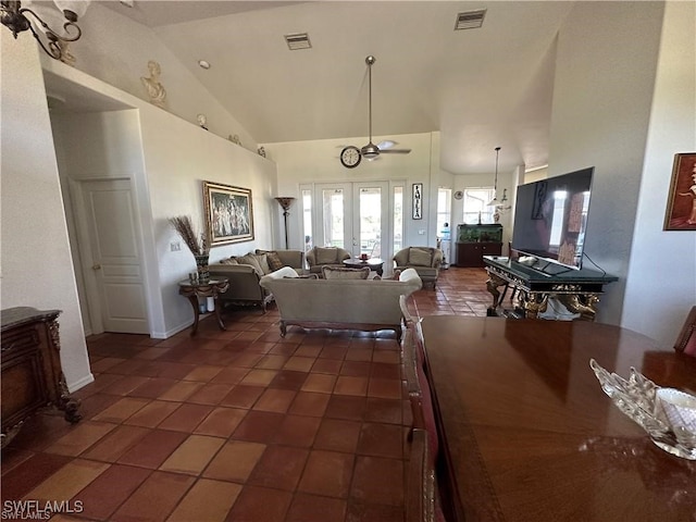 tiled living room with ceiling fan, french doors, and high vaulted ceiling