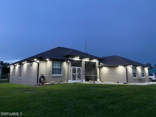 rear view of property with a sunroom and a yard