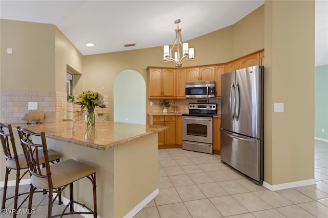 kitchen with decorative backsplash, light tile patterned floors, decorative light fixtures, kitchen peninsula, and stainless steel appliances