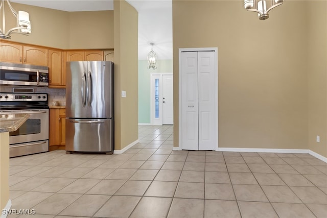 kitchen featuring pendant lighting, stainless steel appliances, and high vaulted ceiling