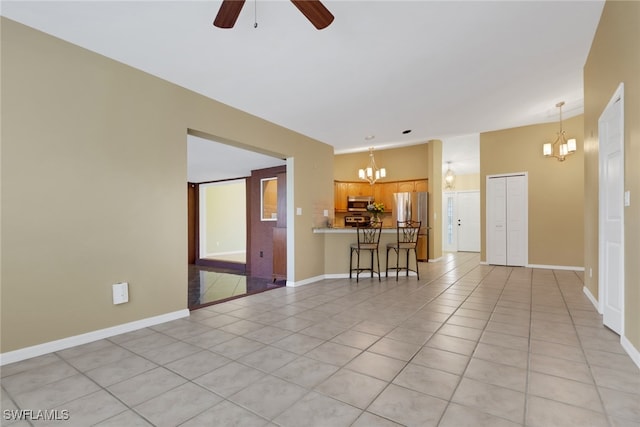 spare room with ceiling fan with notable chandelier and light tile patterned flooring