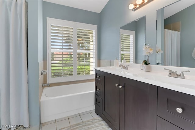 bathroom with a washtub, vanity, tile patterned floors, and plenty of natural light