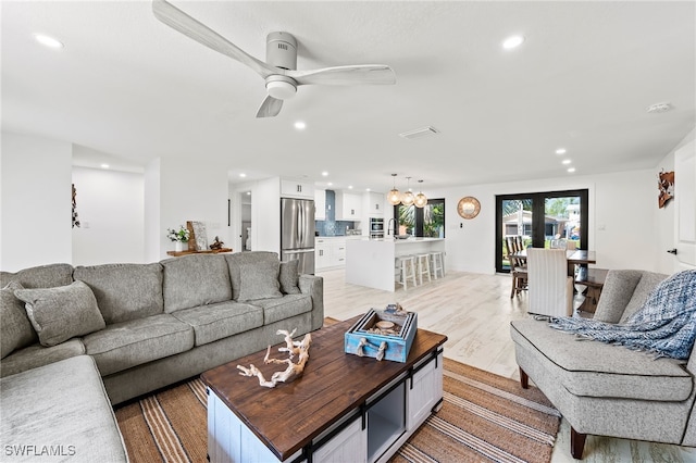 living room with french doors, light hardwood / wood-style floors, and ceiling fan