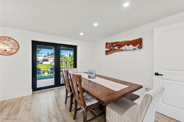 dining space with baseboards, light wood finished floors, and recessed lighting