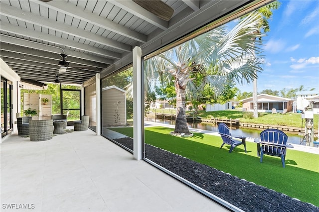 view of patio / terrace with an outbuilding, a water view, and ceiling fan