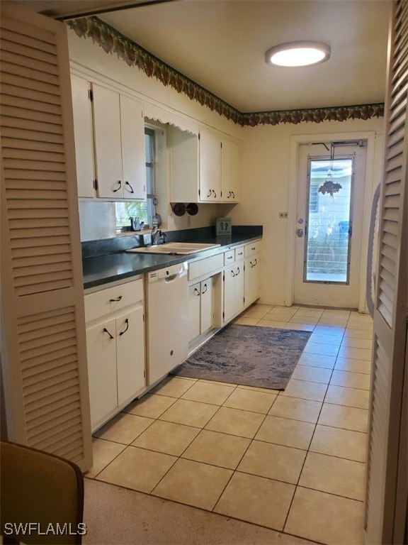 kitchen with white cabinetry, dishwasher, light tile patterned flooring, and sink