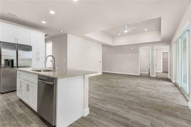 kitchen with visible vents, an island with sink, wood tiled floor, stainless steel appliances, and a sink