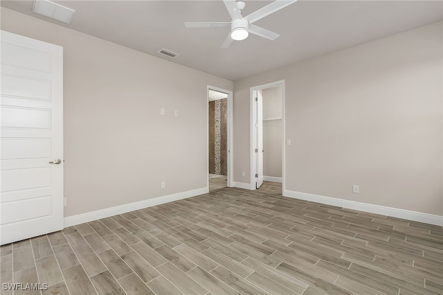 unfurnished room with baseboards, light wood-style flooring, visible vents, and a ceiling fan