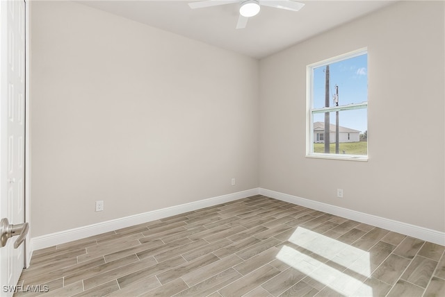 spare room with wood tiled floor, baseboards, and a ceiling fan