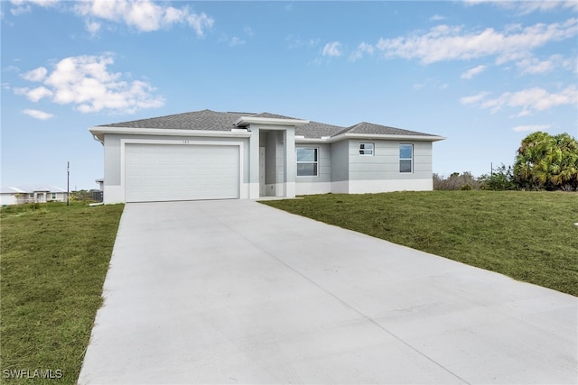 prairie-style house with a garage, driveway, a front lawn, and stucco siding