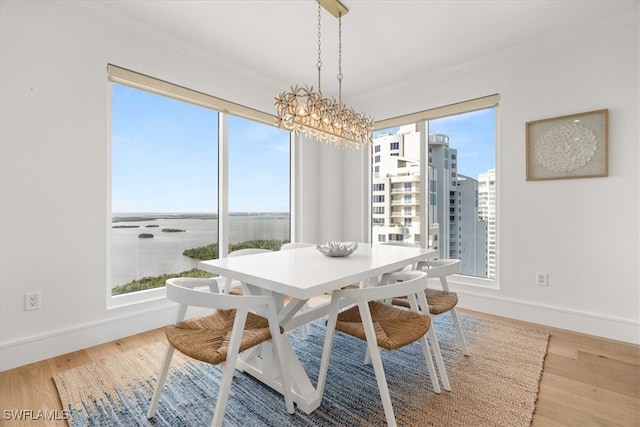 dining space with hardwood / wood-style floors, an inviting chandelier, and ornamental molding