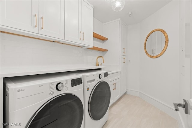 laundry area with cabinets, independent washer and dryer, and sink