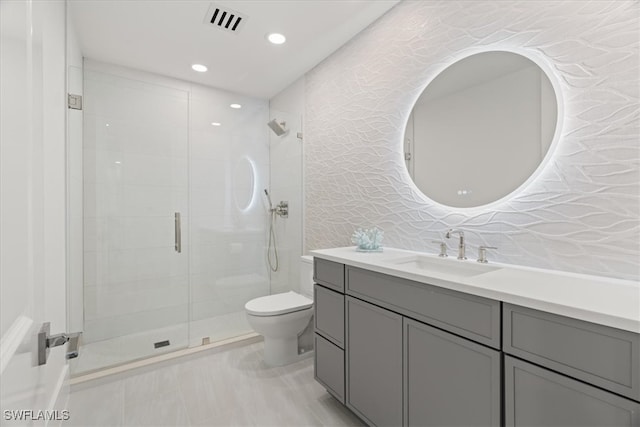 bathroom featuring vanity, toilet, and a shower with shower door