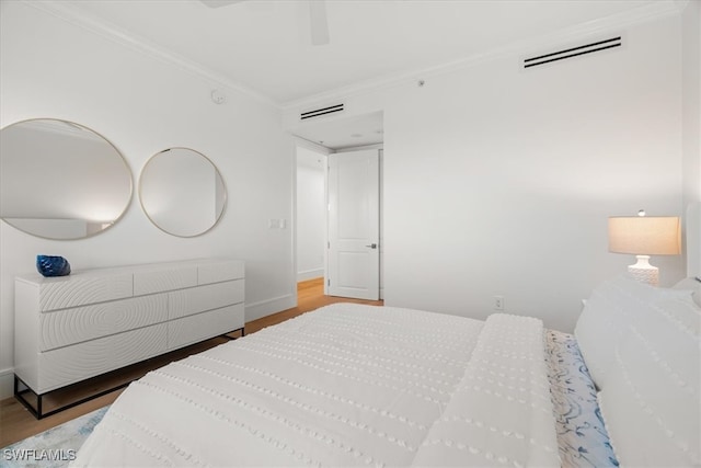 bedroom with ceiling fan, hardwood / wood-style floors, and crown molding